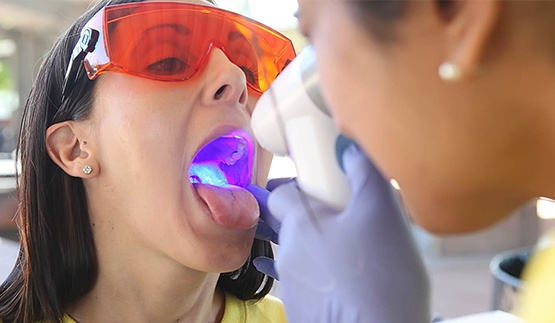 Woman receiving oral cancer screening at dental office