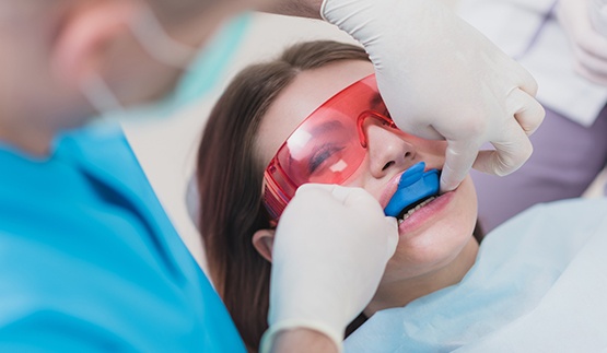 Young woman receiving fluoride treatment at dental office